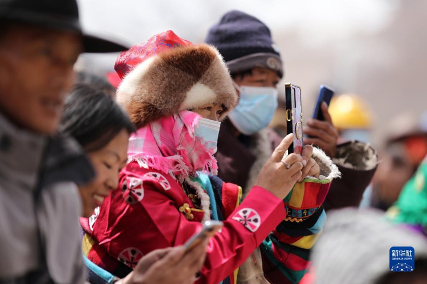 이주 목축민이 스마트폰으로 동네 사람들의 공연 모습을 촬영한다. [2월 28일 촬영/사진 출처: 신화사]