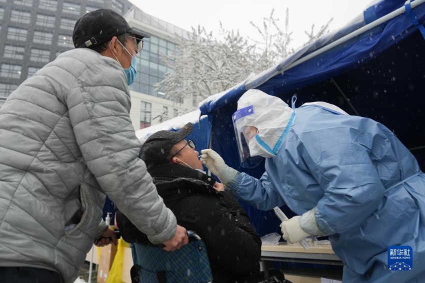 베이징시 둥청구 베이신차오가도에 위치한 핵산검사소에서 의료진이 궂은 날씨에도 핵산 검사를 실시한다. [3월 18일 촬영/사진 출처: 신화사]