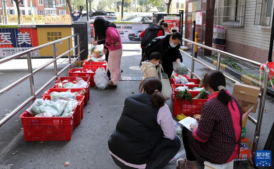 3월 23일, 주민들이 단지 안으로 운송할 야채를 구매하고 있다. [사진 출처: 신화사]