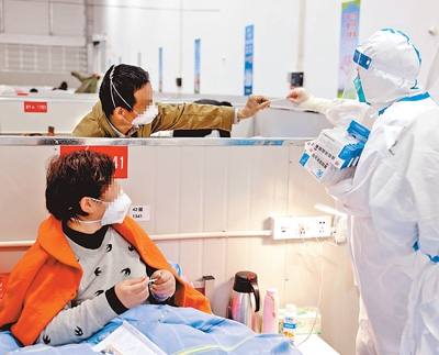 6일 상하이 린강 임시 간이병원에서 의료진이 감염자를 도와 체온을 재고 있다. [사진 출처: 신화사/ 사진 제공: 화산병원]