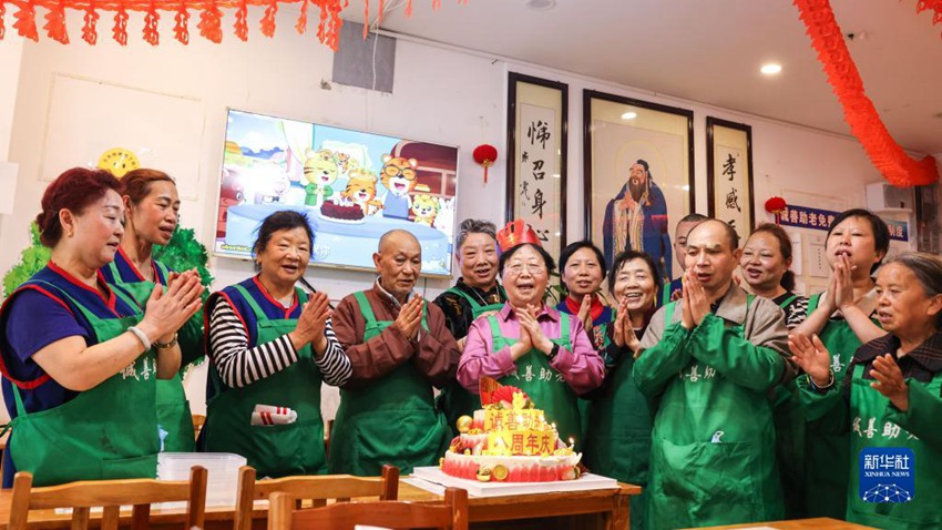 자원봉사자들이 청산 노인돕기 자선공익서비스센터 8주년을 축하하고 있다. [5월 25일 촬영/사진 출처: 신화사]