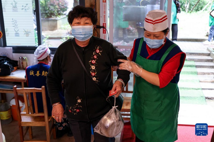 한 노인이 자원 봉사자의 도움을 받으며 식당으로 들어가고 있다. [5월 25일 촬영/사진 출처: 신화사]