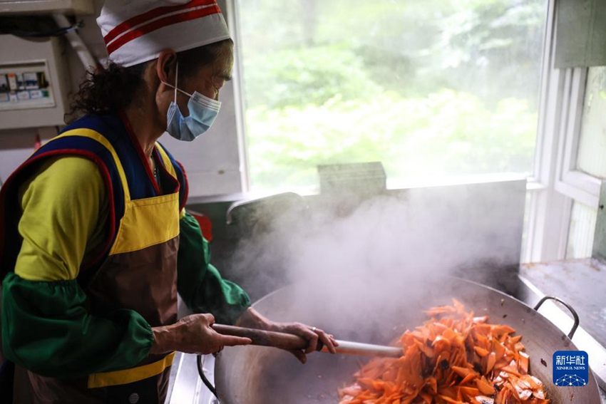 자원 봉사자가 볶음 요리를 하고 있다. [5월 25일 촬영/사진 출처: 신화사]