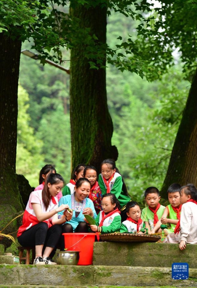 학생들이 촌 부녀자들에게 쭝쯔 만들기를 배운다. [6월 2일 촬영/사진 출처: 신화사]