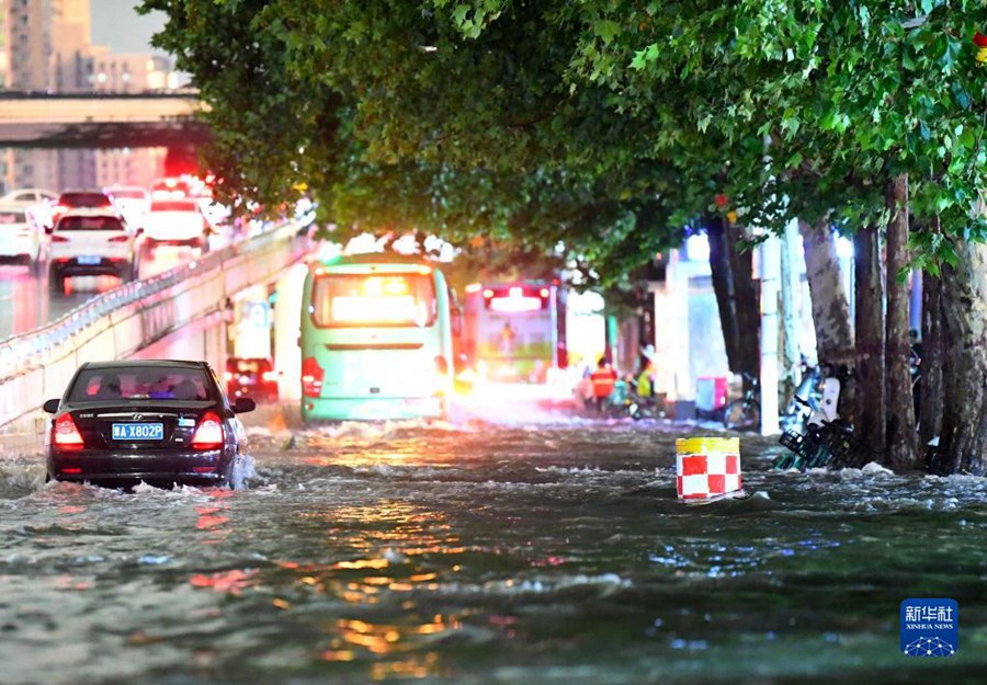 7월 25일, 자동차들이 정저우시 화위안로에서 물살을 가르며 운행하고 있다. [사진 출처: 신화사]