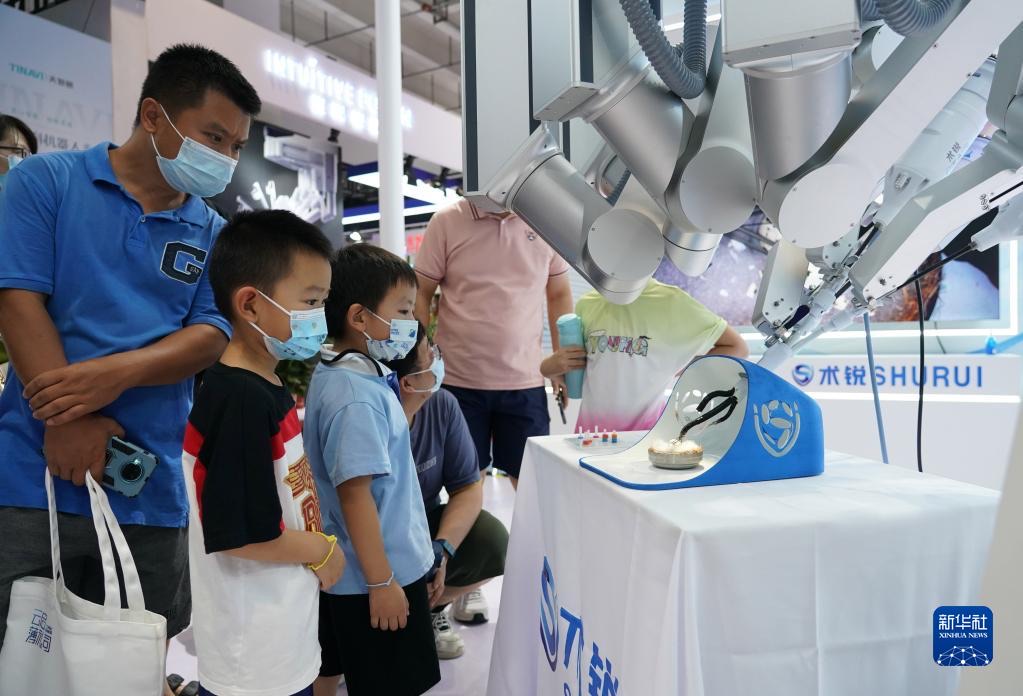 지난 18일 2022 세계로봇콘퍼런스 박람회 현장에서 관람객들이 단공 복강경 수술 로봇을 참관하고 있다. [사진 출처: 신화사]