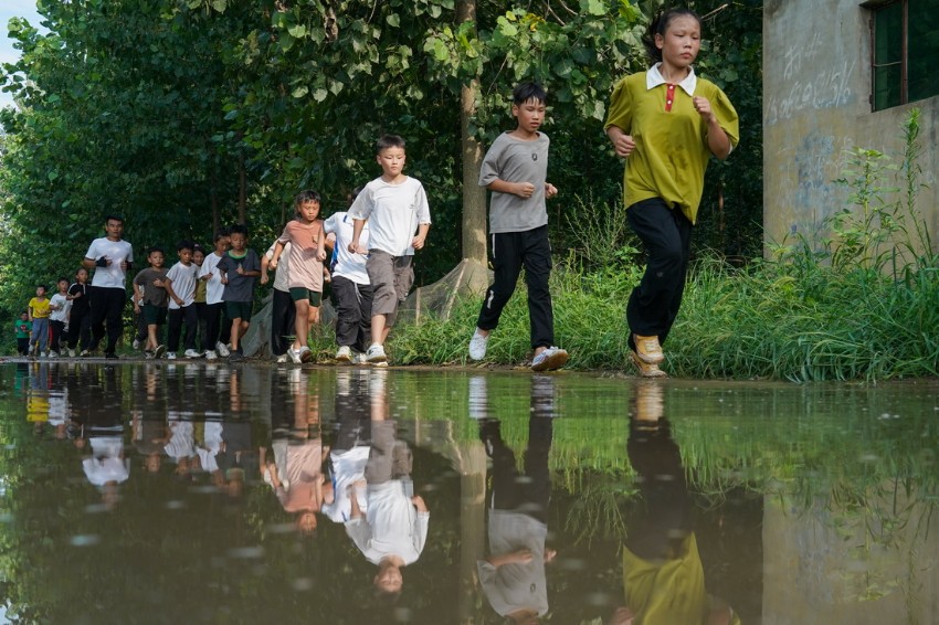 류룽이 아이들과 함께 마을을 뛰며 체력 훈련을 하고 있다. [8월 16일 촬영/사진 출처: 신화사]