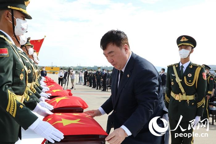 싱하이밍 주한 중국대사가 지원군 열사 유해관을 국기로 덮고 있다. [사진 출처: 인민망]
