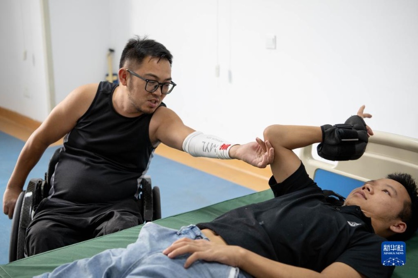 허펑이 환우에게 팔 힘 기르는 방법을 설명하고 있다. [8월 27일 촬영/사진 출처: 신화사]