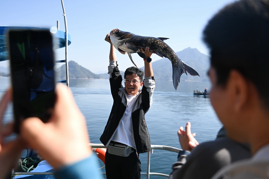 10월 22일 저장성 춘안현 첸다오호 황산젠 수역에서 관광객이 방금 막 잡은 ‘물고기 왕’을 양팔로 들어올리고 있다. 