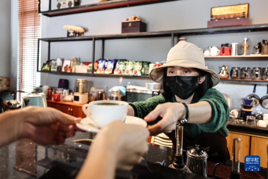 옌춘구이(嚴春桂) 바리스타가 손님에게 직접 내린 커피를 전해주고 있다. [12월 10일 촬영/사진 출처: 신화사]