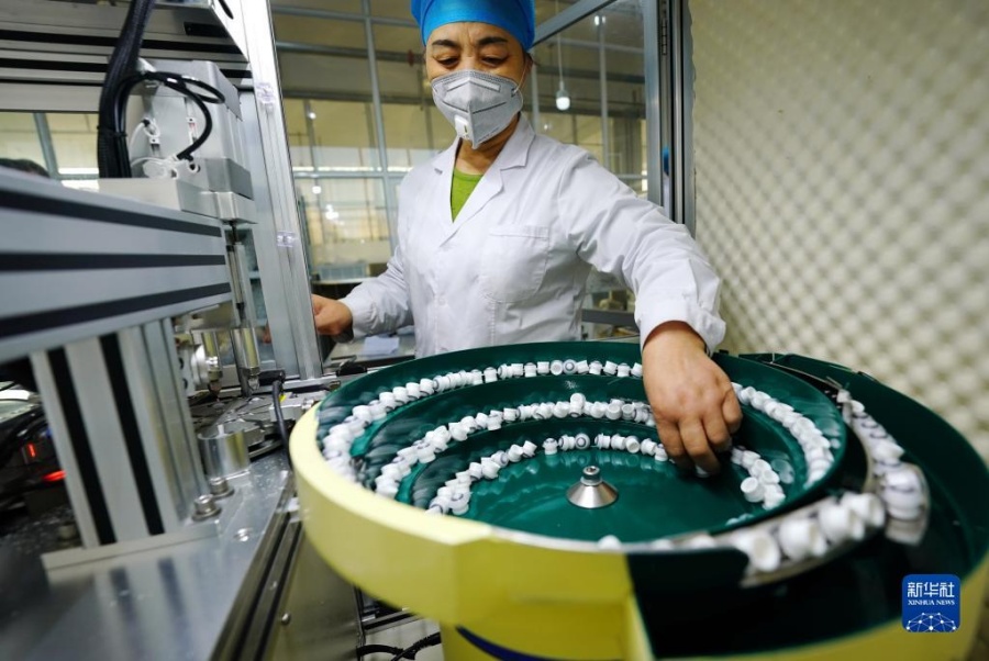 한 렌즈기업 직원이 생산라인에서 작업하고 있다. [12월 29일 촬영/사진 출처: 신화사]