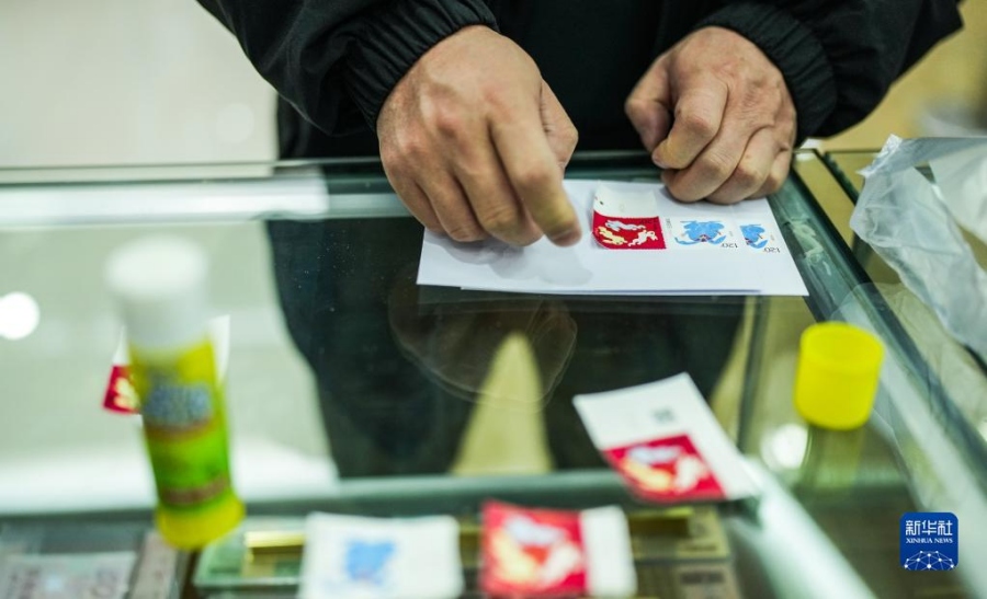 1월 5일, 시민이 구이양시 한 우체국에서 ‘계묘년’ 특별 우표를 붙이고 있다. [사진 출처: 신화사]