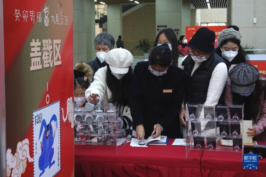 1월 5일, 광시(廣西) 난닝(南寧)시의 우표 수집가들이 엽서 등에 십이간지 기념 도장을 찍는다. [사진 출처: 신화사]