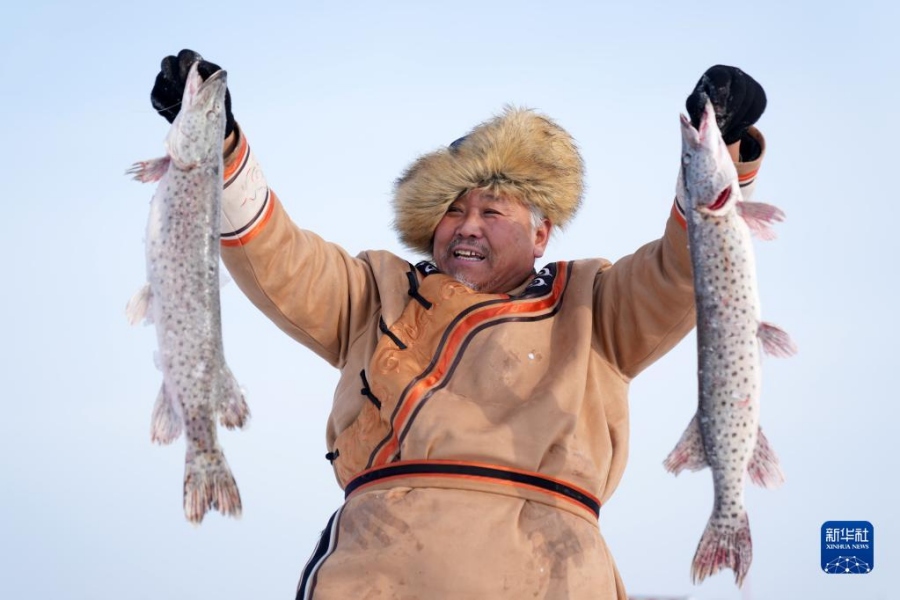 1월 11일, 허저족이 갓 잡은 물고기를 보여준다. [사진 출처: 신화사]