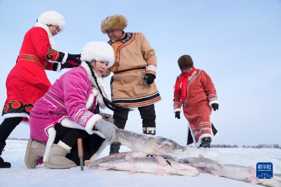 1월 11일, 허저족이 갓 잡은 물고기를 손질한다. [사진 출처: 신화사]