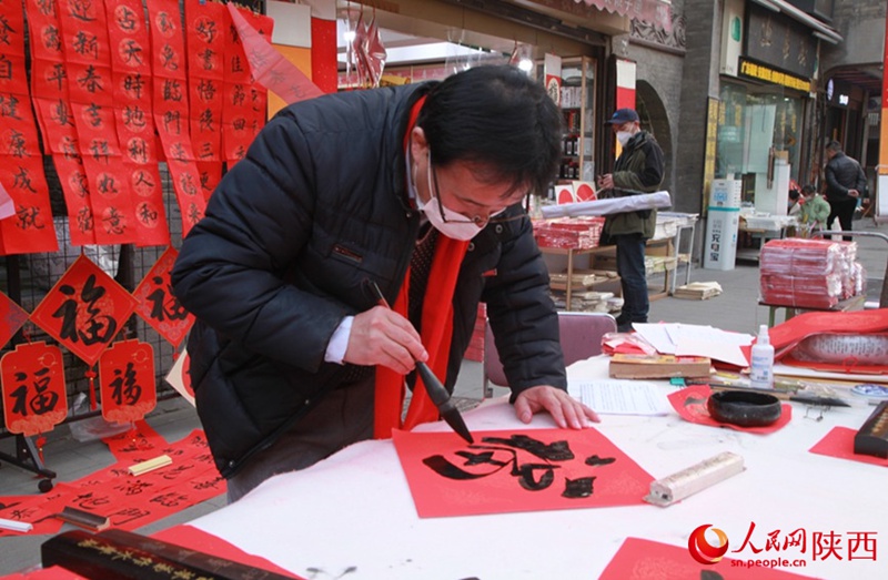 한 노점 주인이 손님을 위한 ‘福(복)’자를 쓴다. [사진 출처: 인민망]