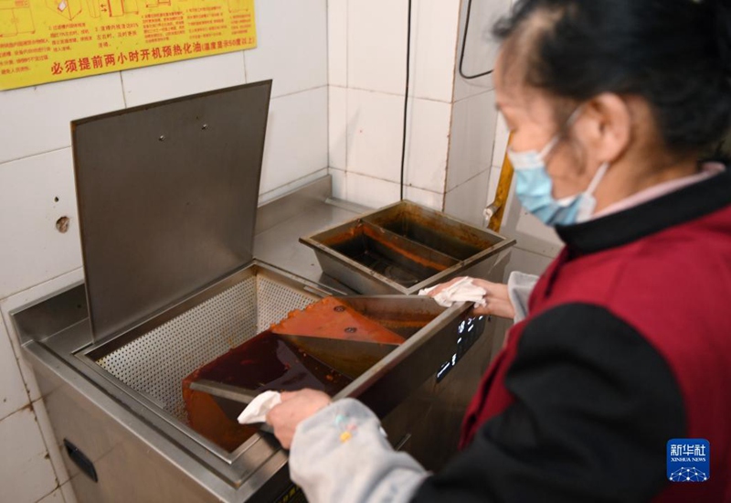 2월 25일, 청두의 한 훠궈집 직원이 훠궈 잔반을 물과 기름 분리기에 넣은 후 폐식용유를 모은다. [사진 출처: 신화사]