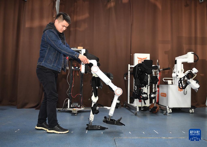 3월 6일, 전자과학기술대학교 로봇연구센터 연구원이 외골격 로봇에 대한 테스트를 진행한다. [사진 출처: 신화사]