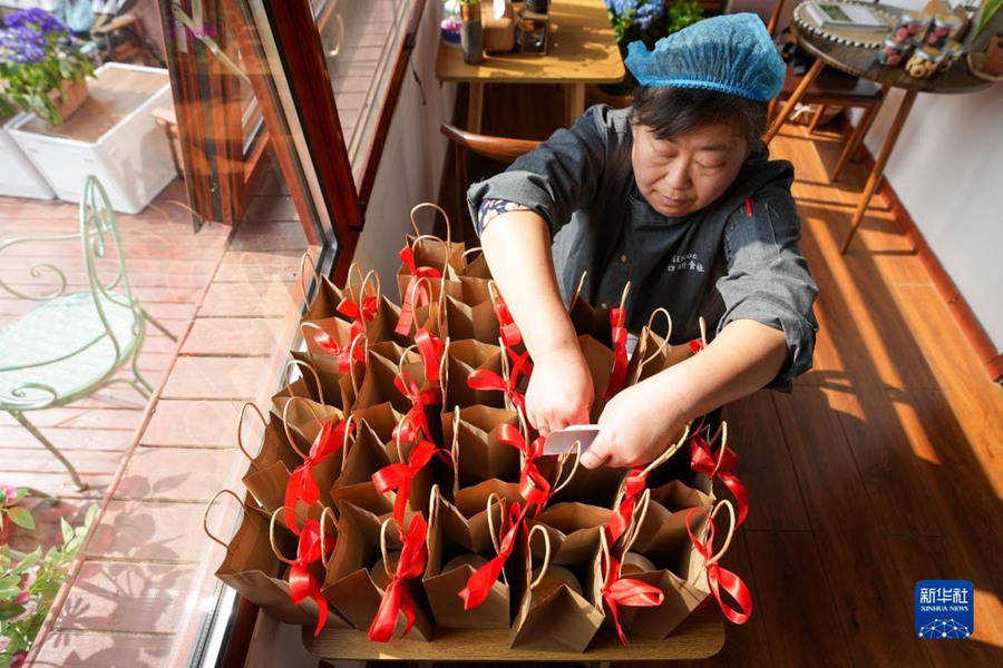 양훙옌 씨가 고객들이 예약한 샤오미쑤 기념품을 포장하고 있다. [2023년 3월 7일 촬영/사진 출처: 신화사]