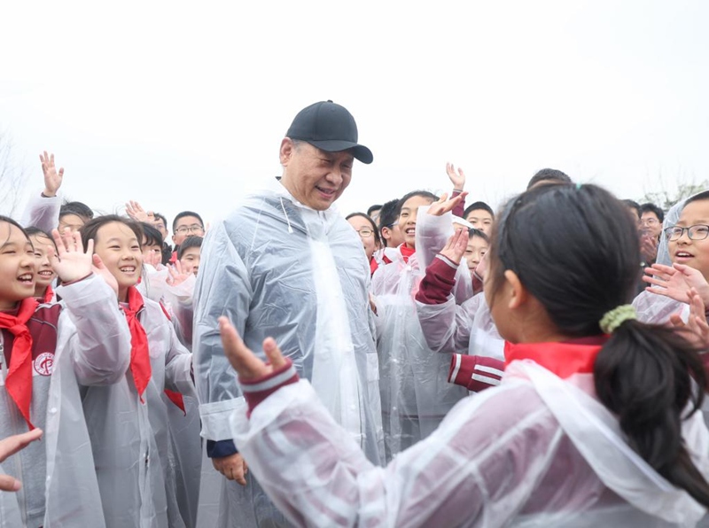 나무를 심은 뒤 시진핑 주석이 현장에 있던 초중고교생들과 환담을 나누고 있는 모습 [사진 출처: 신화사]