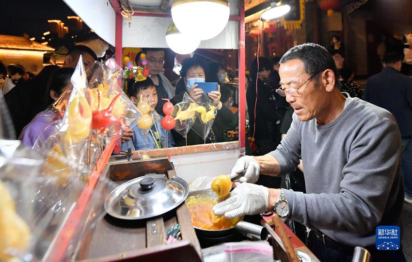 지난달 29일 톈진 고문화거리에서 수공예가가 여행객들에게 설탕인형(糖人)을 만들어주고 있다. [사진 출처: 신화사]