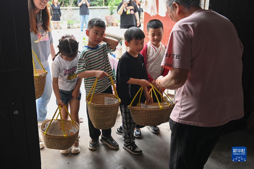 어린이들이 바구니를 들고서 집집마다 돌며 모은 식재료로 ‘야미반’을 짓는다. [5월 4일 촬영/사진 출처: 신화사]