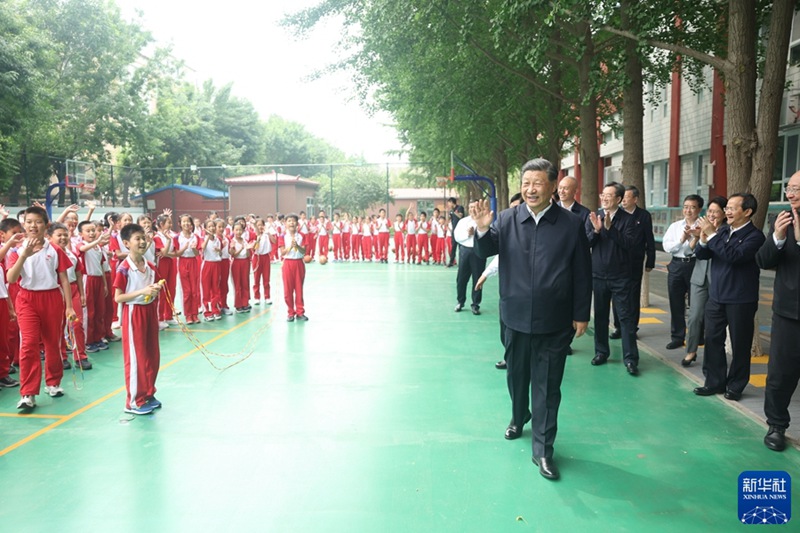 시진핑 주석이 농구장에서 체육수업 중인 초등학생들에게 손을 흔들고 있다. [사진 출처: 신화사]
