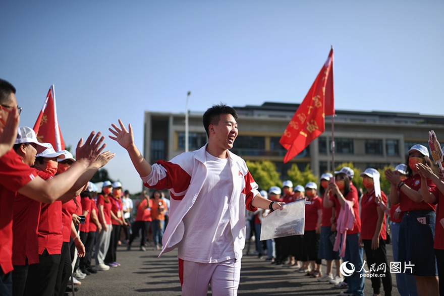 베이징시 인민대학교 부속 고등학교 퉁저우(通州)캠퍼스 수험장에서 수험생이 선생님들과 하이파이브하고 있다. [사진 출처: 인민망]