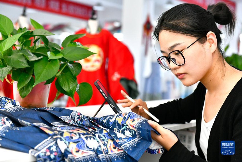 량리(梁莉) 디자이너가 마몐췬(馬面裙: 중국 전통 주름치마)의 자수 패턴을 디자인하고 있다. 량리는 시난(西南)대학교 졸업 후 고향으로 돌아가 디자인 일을 하고 있다. [7월 6일 촬영/사진 출처: 신화사]