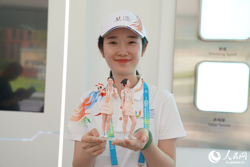 선수촌 과학기술 서비스 센터에서  자원봉사자가 3D 프린팅으로 제작한 자신의 모형을 들고 있다. [사진 출처: 인민망]