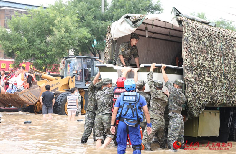 8월 2일 오전 줘저우시 107번 국도 피해 구간에 수십 명의 무장경찰 모 부대 장병들이 도착해 이재민들에게 음식과 식수를 보낼 준비를 했다. 사진은 무장경찰 장병들이 쾌속정을 운반하는 모습. [사진 출처: 인민망]
