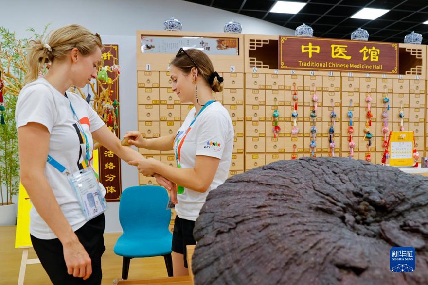 오스트리아 대표단원 두 명이 선수촌에서 중국 전통의학 과사(刮痧, 괄사)를 체험해 본다. [7월 31일 촬영/사진 출처: 신화사]