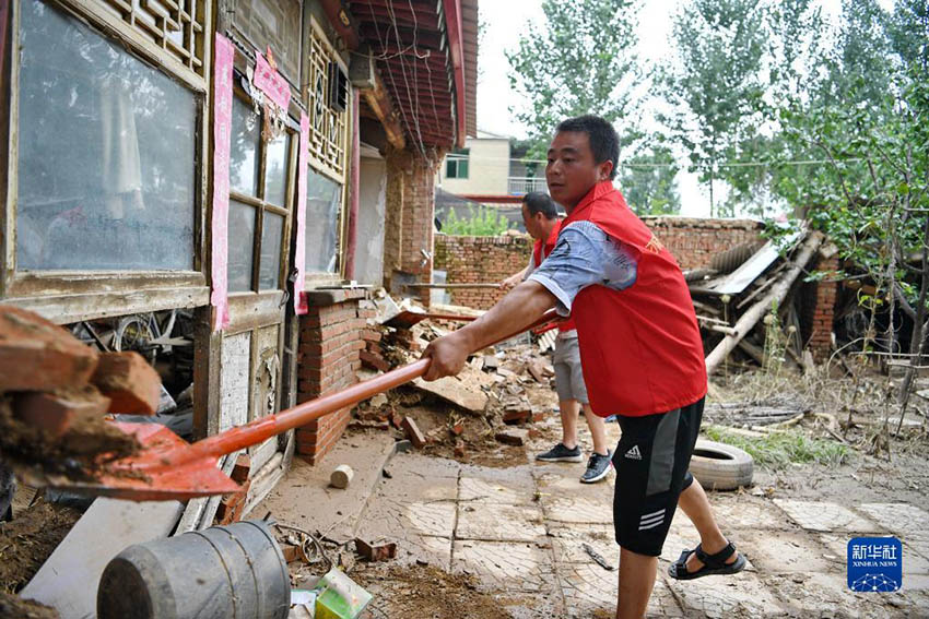 허베이성 줘저우시 댜오워(刁窩)진 바이타(白塔)촌에서 자원봉사자들이 홍수로 무너진 집 앞을 치우고 있다. [8월 6일 촬영/사진 출처: 신화사]