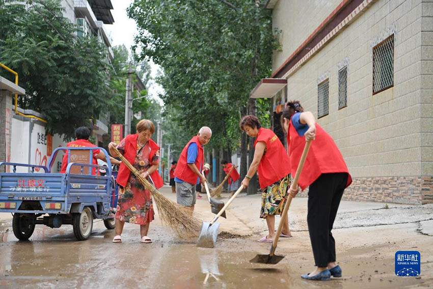 자원봉사자들이 거리에서 준설 작업을 하고 있다. [8월 6일 촬영/사진 출처: 신화사]