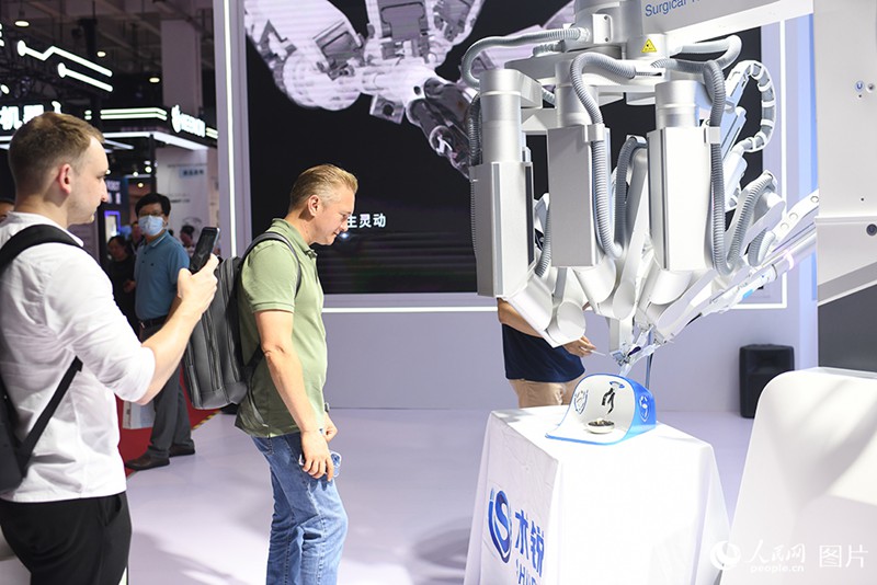 8월 16일, 관람객들이 2023 WRC 현장에서 수술용 로봇을 구경하고 있다. [사진 출처: 인민망]