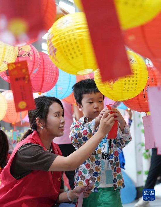 9월 26일, 충칭(重慶)시 베이베이(北碚)구 청장(澄江)진 신시대문명실천센터에서 자원봉사자와 어린이가 함께 수수께끼 놀이를 한다. 