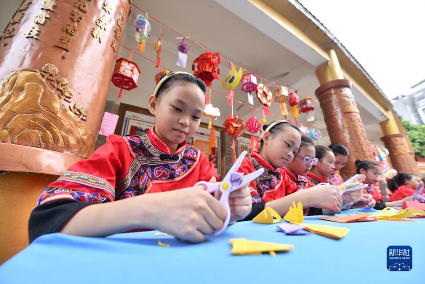 9월 28일, 광시성 우저우시 룽웨이구 룽웨이중심초등학교에서 학생들이 전통 종이 공예, 전지를 하는 중이다. 