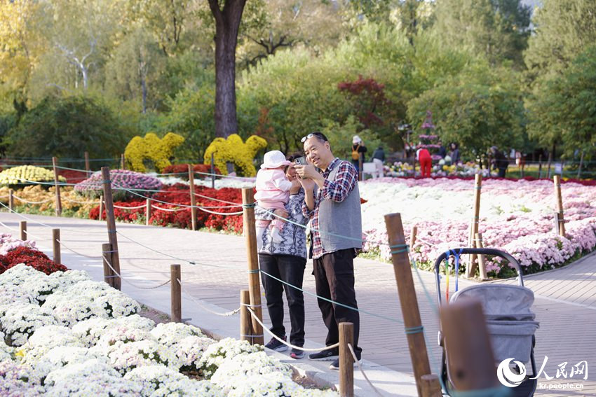 관광객들이 중국국가식물원 꽃밭에서 기념 촬영을 하고 있다. [사진 출처: 인민망]