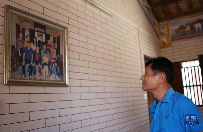 하이난성 충하이(瓊海)시 본가에서 황훙보가 벽에 걸린 가족사진을 보고 있다. 황훙보는 베이다오에서 일할 때 집에 자주 오지 못했다. [9월 19일 촬영/사진 출처: 신화사]