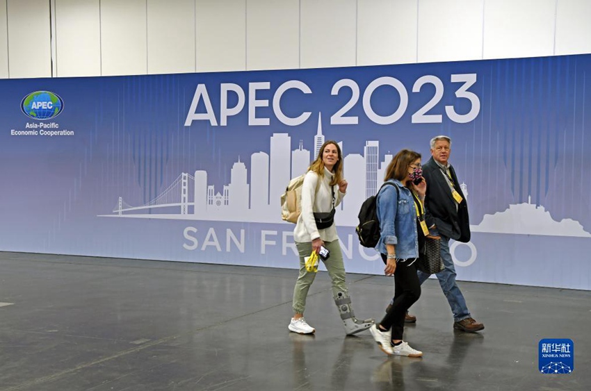 미국 샌프란시스코에 있는 2023년 APEC 회의 국제미디어센터에서 기자들이 포스터 앞을 지나고 있다. [11월 12일 촬영/사진 출처: 신화사]