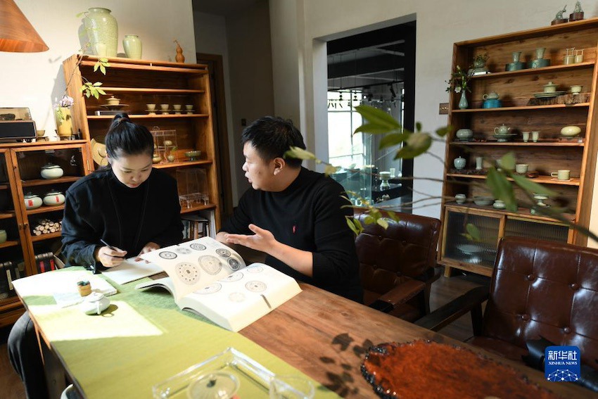 지솽쥔(오른쪽)과 지쯔메이가 중국 전통 문양을 대조하며 작품 디자인을 의논하고 있다. [10월 31일 촬영/사진 출처: 신화사]