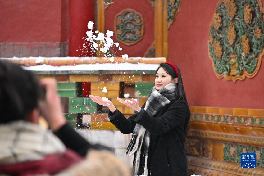 관광객들이 눈 내린 고궁을 배경으로 사진을 찍고 있다. [사진 출처: 신화사]