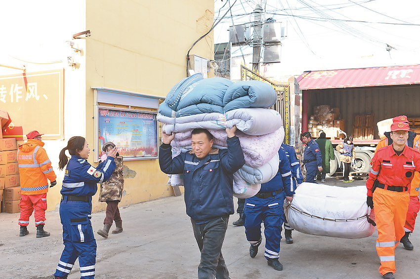 간쑤성 지스산현 스위안(石塬)진 주민센터에서 구조대원이 구호 물품을 내리고 있다. [12월 23일 촬영/사진 출처: 인민일보]
