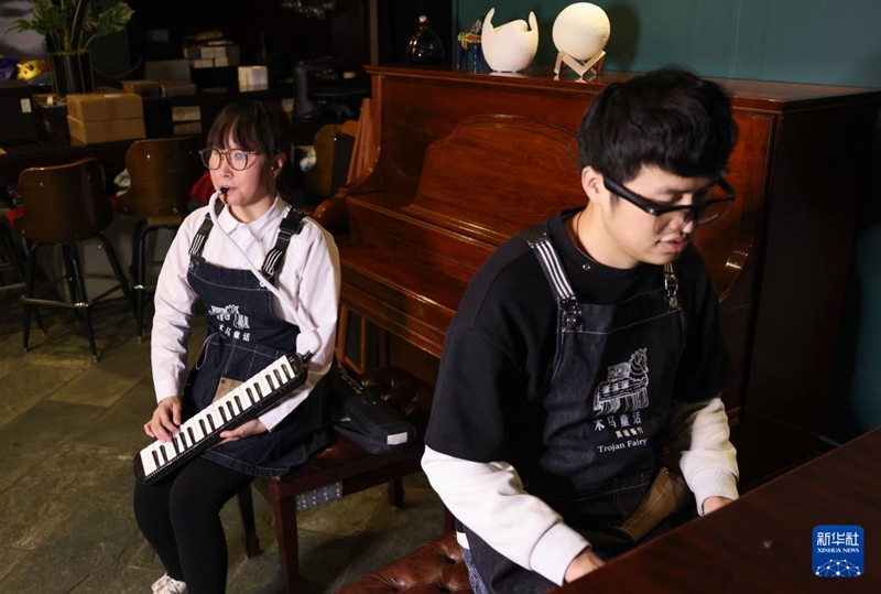 2023년 12월 22일, 시각장애인 즈밍(왼쪽) 씨와 양더민 씨가 식당에서 연주하고 있다. [사진 출처: 신화사]