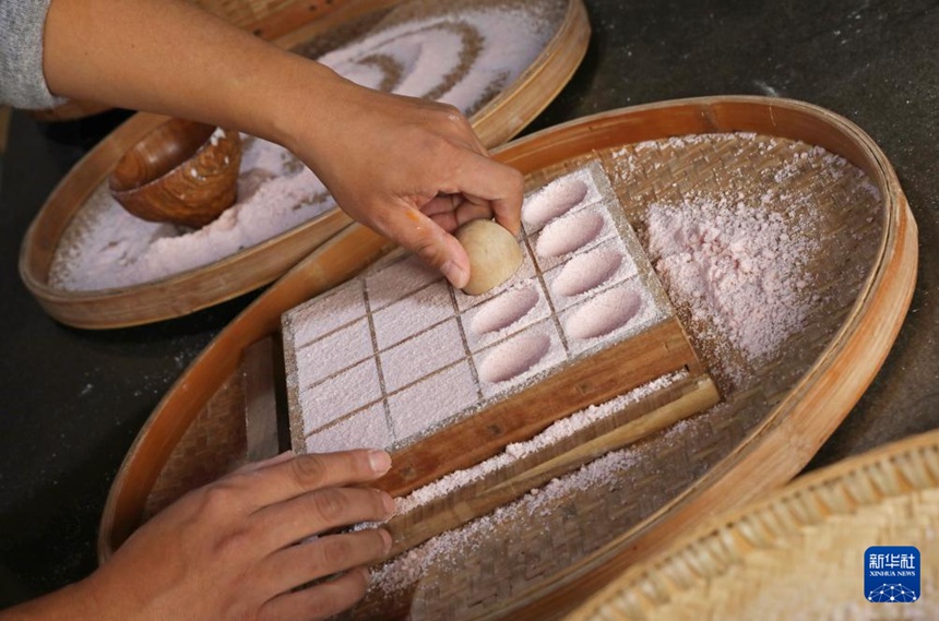 양친펑 씨가 쌀가루를 틀에 가득 담아 달걀 모양의 도구로 모양을 내고 있다. [1월 10일 촬영/사진 출처: 신화사]