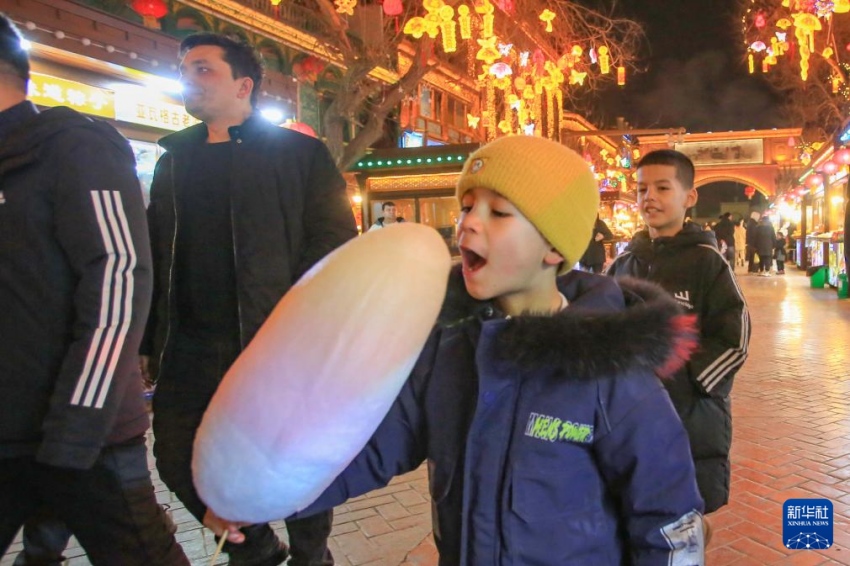 어린이가 신장 카스 고성 한바자 야시장에서 솜사탕을 먹는다. [2월 4일 촬영/사진 출처: 신화사]