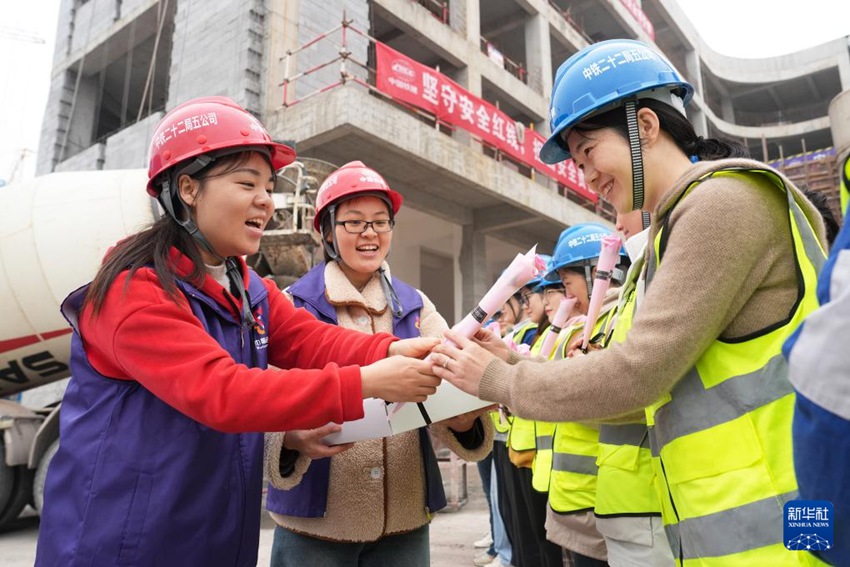 베이베이구 부녀자연합회 여성 자원봉사자들이 중톄(中鐵) 22국 5공사 여성 직원들에게 꽃다발을 증정하며 축복한다. [3월 5일 촬영/사진 촬영: 친팅푸]