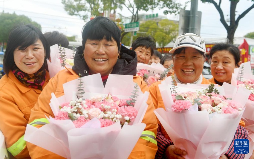 저장(浙江)성 타이저우(台州)시 루차오(路橋)구 루난(路南)가도[街道: ‘구(區)’ 아래의 작은 행정단위로 한국의 ‘동’에 해당]의 여성 환경미화원들이 현지 부녀자연합회에서 증정한 꽃다발을 받는다. [3월 6일 촬영/사진 촬영: 왕바오추(王保初)]