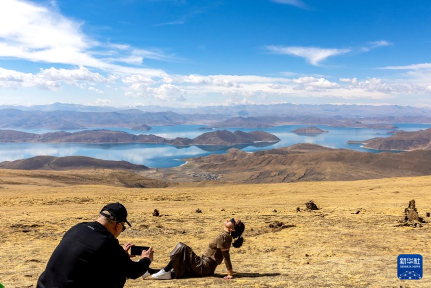 관광객들이 카칭라(喀庆拉)산에서 양줘융춰 호수를 배경으로 기념사진을 찍는다. [4월 5일 촬영/사진 출처: 신화사]